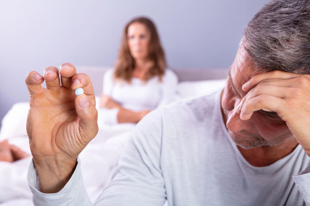 Man holding a pill for erectile dysfunction