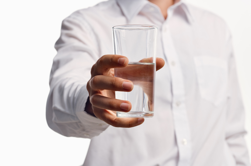 Close up of a man holding a glass of water