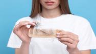 Woman with hair loss holding a comb